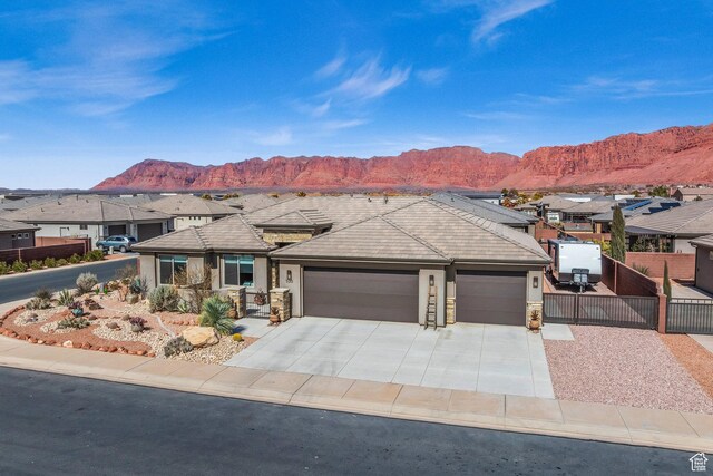 530 W Cougar Way, Ivins, UT 84738 - view of front of home with a garage, concrete driveway, a mountain view, and fence