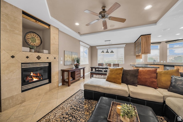 806 N 2500 W, Hurricane, UT 84737 - living area featuring light tile patterned flooring, a fireplace, a raised ceiling, and a wealth of natural light
