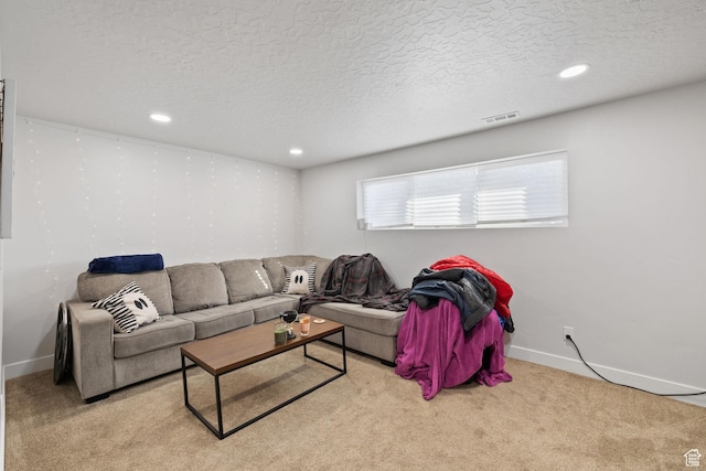carpeted living room featuring a textured ceiling, visible vents, and baseboards