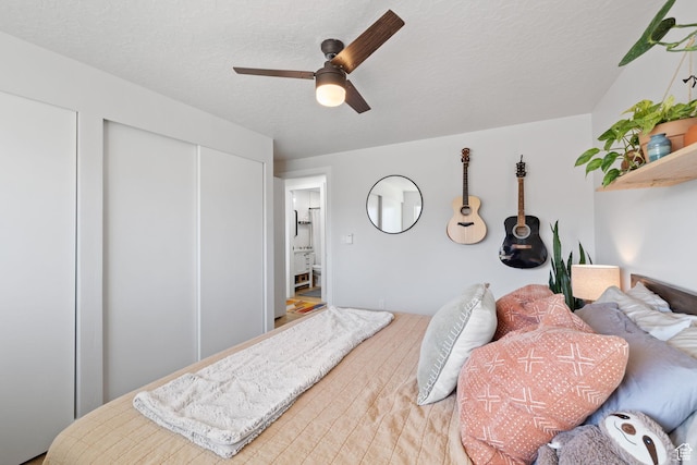 bedroom with a closet, ceiling fan, and a textured ceiling