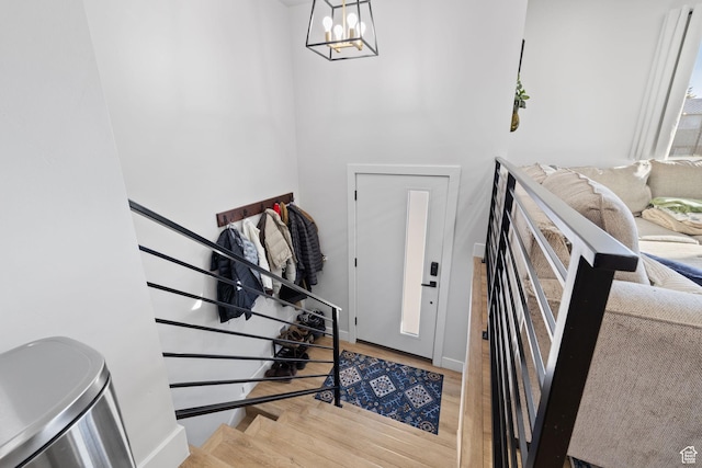 foyer entrance featuring a notable chandelier, stairway, and wood finished floors
