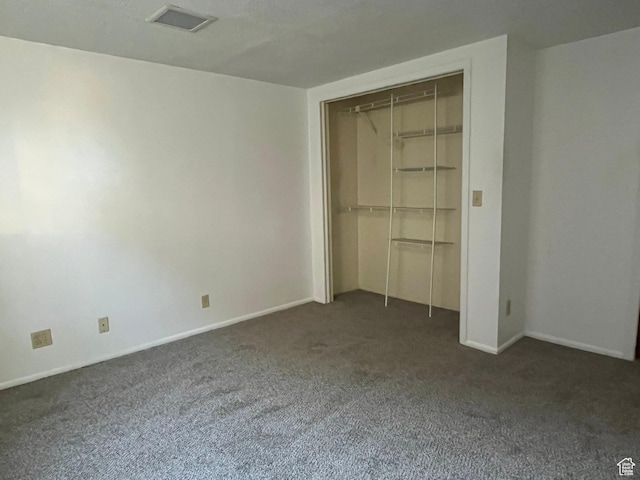 unfurnished bedroom featuring baseboards, carpet, visible vents, and a closet