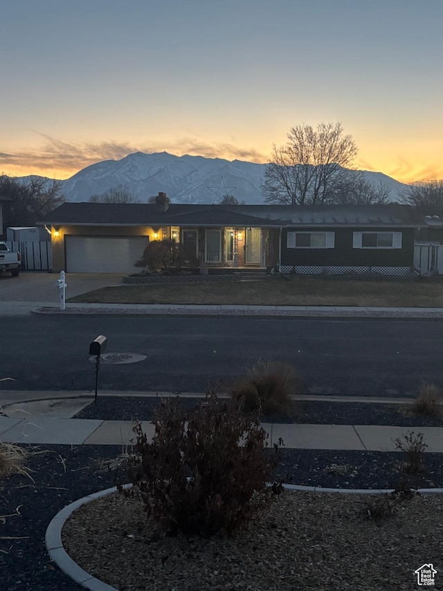 exterior space with driveway, an attached garage, and a mountain view