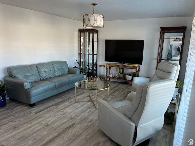 living area featuring a notable chandelier and wood finished floors