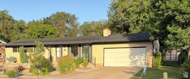 4527 S 2300 W, Roy, UT 84067 - ranch-style home with an attached garage, driveway, a chimney, and brick siding