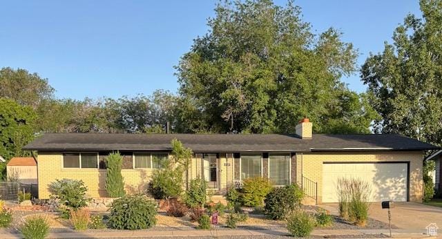 4527 S 2300 W, Roy, UT 84067 - ranch-style house featuring brick siding, an attached garage, a chimney, and concrete driveway