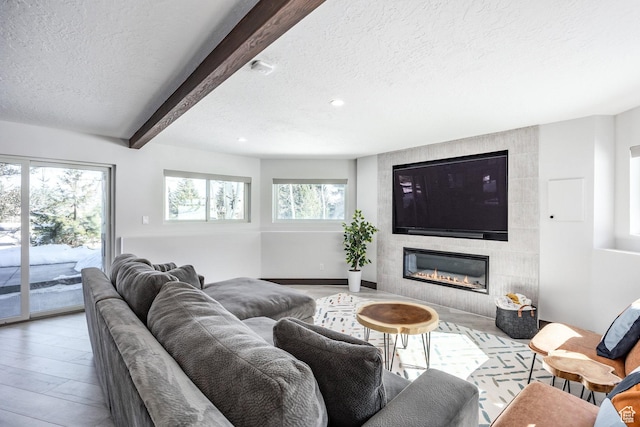 12 Thaynes Canyon Dr, Park City, UT 84060 - living room featuring a tiled fireplace, a textured ceiling, wood finished floors, beamed ceiling, and baseboards