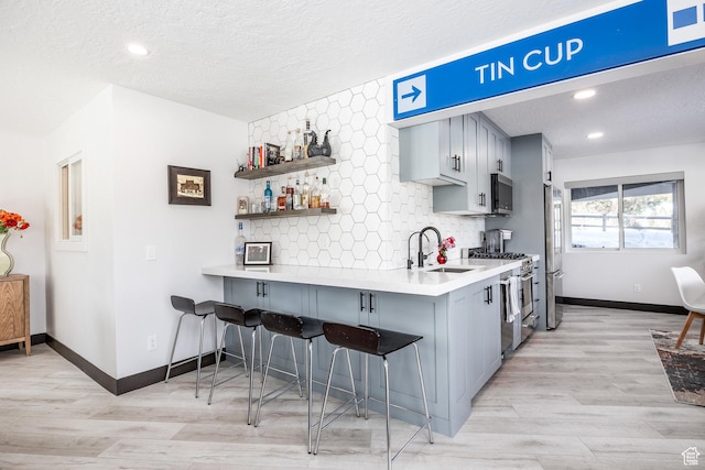 12 Thaynes Canyon Dr, Park City, UT 84060 - kitchen with premium appliances, a sink, light countertops, decorative backsplash, and a kitchen bar
