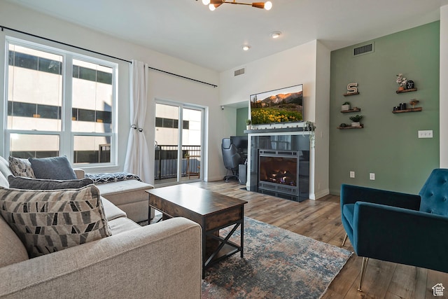 350 S 200 E Unit 404, Salt Lake City, UT 84111 - living area featuring a lit fireplace, wood finished floors, visible vents, and baseboards