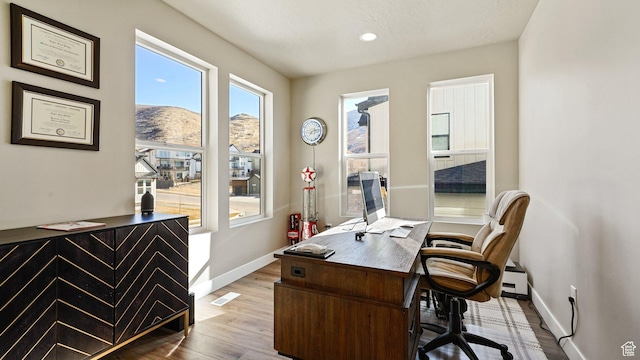 home office featuring recessed lighting, wood finished floors, visible vents, baseboards, and a baseboard radiator