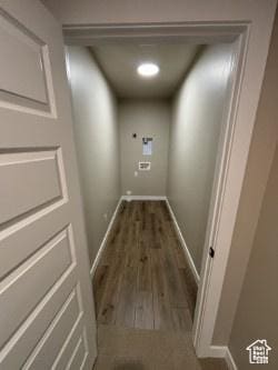 corridor featuring wood finished floors and baseboards