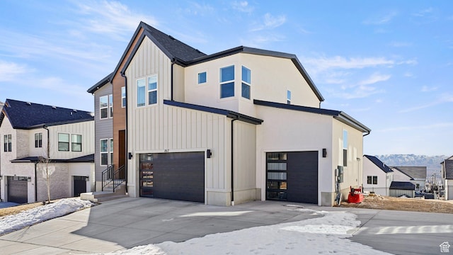 view of front of house with concrete driveway, an attached garage, and board and batten siding