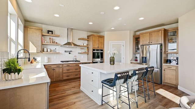 kitchen featuring open shelves, stainless steel appliances, backsplash, wall chimney exhaust hood, and a kitchen island