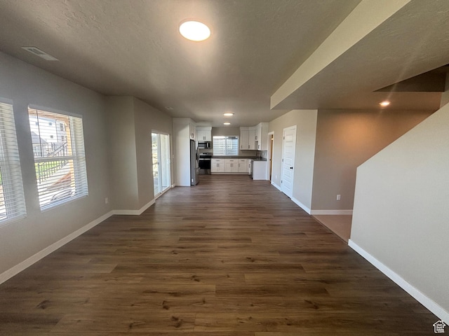 unfurnished living room featuring recessed lighting, visible vents, baseboards, and dark wood-style flooring