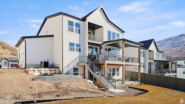 back of house featuring stairway, fence, a mountain view, and central AC unit