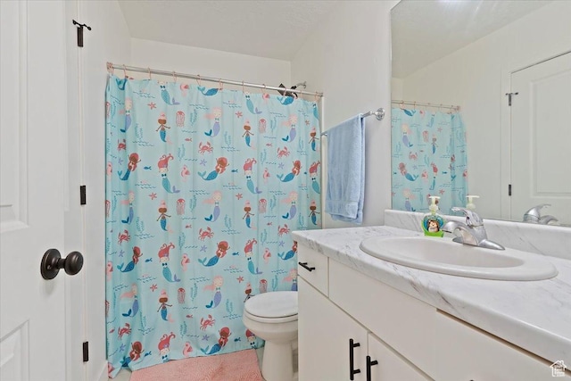 bathroom featuring curtained shower, vanity, and toilet