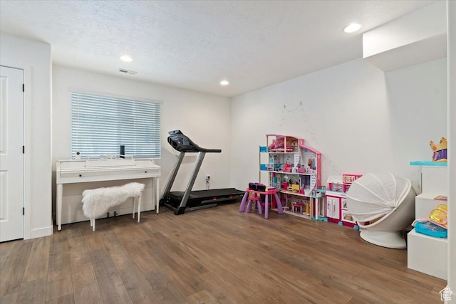 playroom with recessed lighting, visible vents, a textured ceiling, and wood finished floors