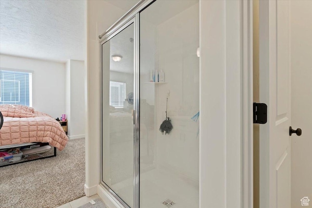 ensuite bathroom featuring a stall shower, ensuite bath, and a textured ceiling