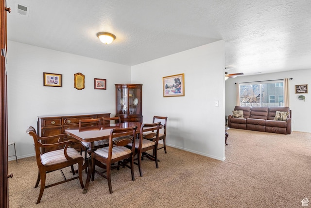 5906 Columbus Cir, Stansbury Park, UT 84074 - dining area with light carpet, a textured ceiling, ceiling fan, and baseboards