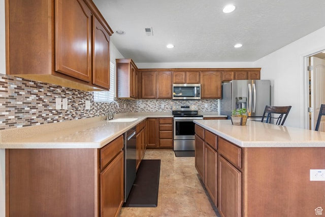 5906 Columbus Cir, Stansbury Park, UT 84074 - kitchen featuring appliances with stainless steel finishes, a sink, a kitchen island, tasteful backsplash, and light countertops