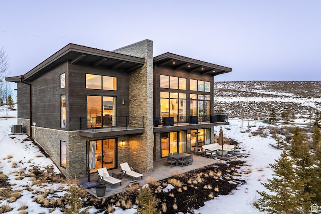 6379 W Golden Bear Loop, Park City, UT 84098 - snow covered back of property with a chimney, stone siding, a patio, and a balcony