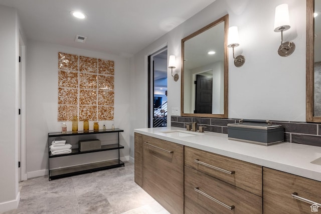 6379 W Golden Bear Loop, Park City, UT 84098 - bathroom featuring tasteful backsplash, baseboards, double vanity, visible vents, and a sink