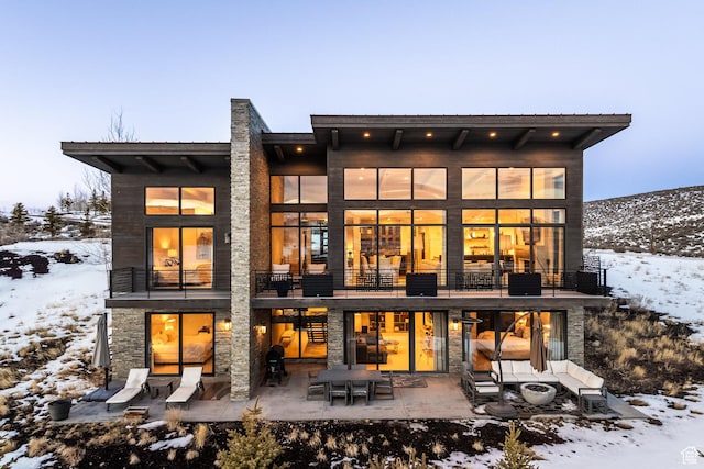 6379 W Golden Bear Loop, Park City, UT 84098 - snow covered back of property with a patio area, stone siding, and a balcony