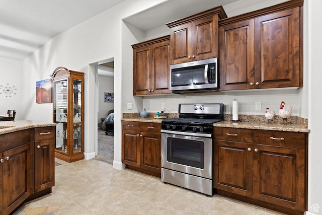 529 E Dry Ln, Washington, UT 84780 - kitchen with appliances with stainless steel finishes, light stone counters, and dark brown cabinetry