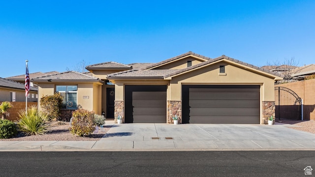 view of front of home with stucco siding, fence, a garage, stone siding, and driveway
