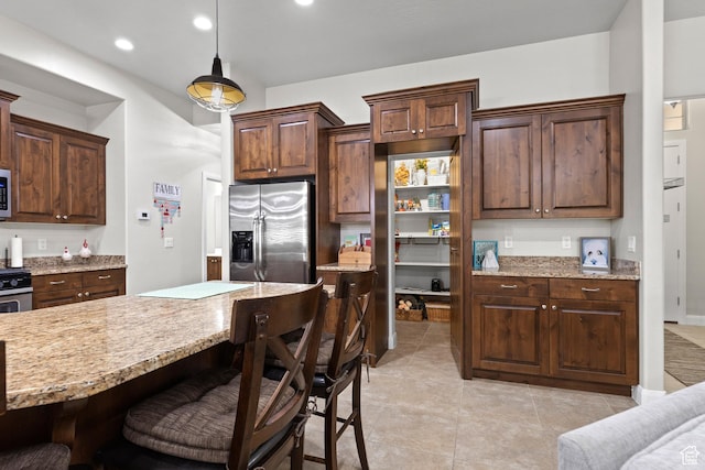 529 E Dry Ln, Washington, UT 84780 - kitchen with appliances with stainless steel finishes, a breakfast bar area, hanging light fixtures, light stone countertops, and recessed lighting