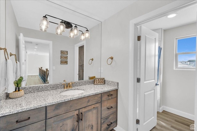 bathroom featuring baseboards, wood finished floors, and vanity