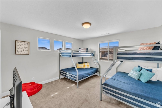carpeted bedroom featuring baseboards and a textured ceiling