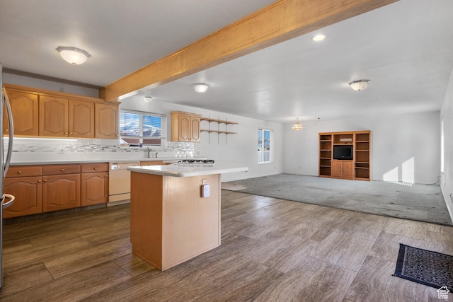 kitchen featuring white dishwasher, open floor plan, light countertops, tasteful backsplash, and beamed ceiling