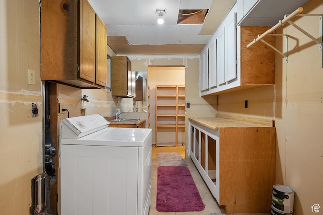 washroom featuring washer / clothes dryer, a sink, and cabinet space
