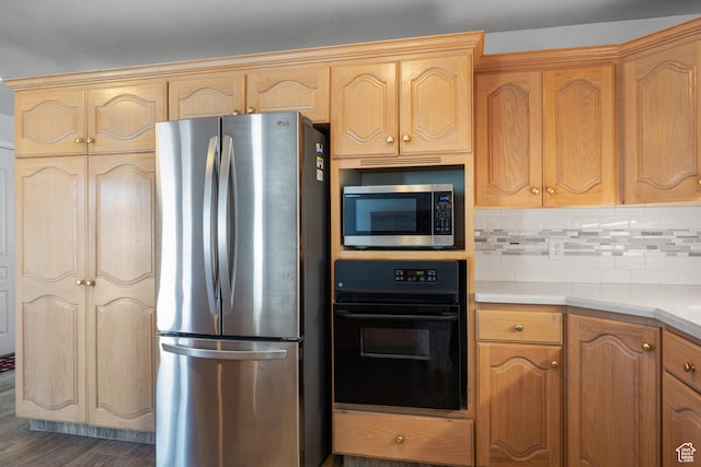 kitchen featuring light countertops, appliances with stainless steel finishes, dark wood-type flooring, and backsplash