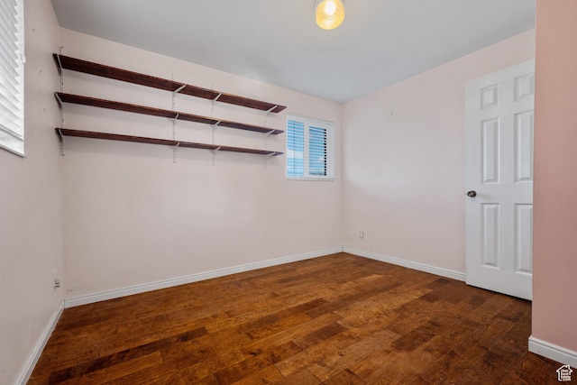 spare room featuring baseboards and wood finished floors
