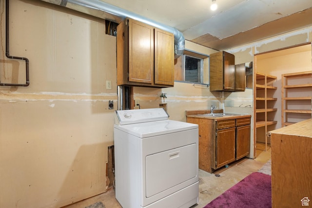 washroom with washer / clothes dryer, cabinet space, and a sink