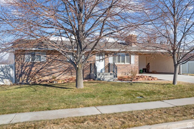 ranch-style house with concrete driveway, a front lawn, a chimney, and brick siding