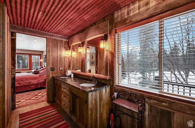 8979 N Timphaven Dr, Sundance, UT 84604 - ensuite bathroom featuring double vanity, connected bathroom, wooden ceiling, wood walls, and a sink
