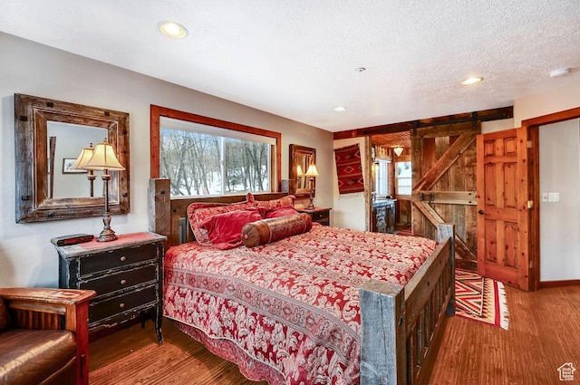 8979 N Timphaven Dr, Sundance, UT 84604 - bedroom with a textured ceiling, a barn door, wood finished floors, and recessed lighting
