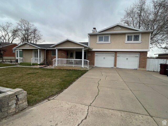 view of front of property featuring a garage, brick siding, stucco siding, covered porch, and a front yard