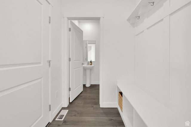 mudroom with dark wood-style floors, visible vents, and baseboards