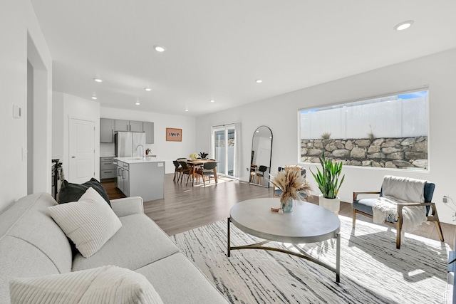 living area with recessed lighting, dark wood-type flooring, and a healthy amount of sunlight