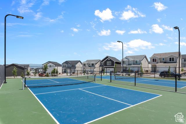 view of tennis court featuring a residential view and fence