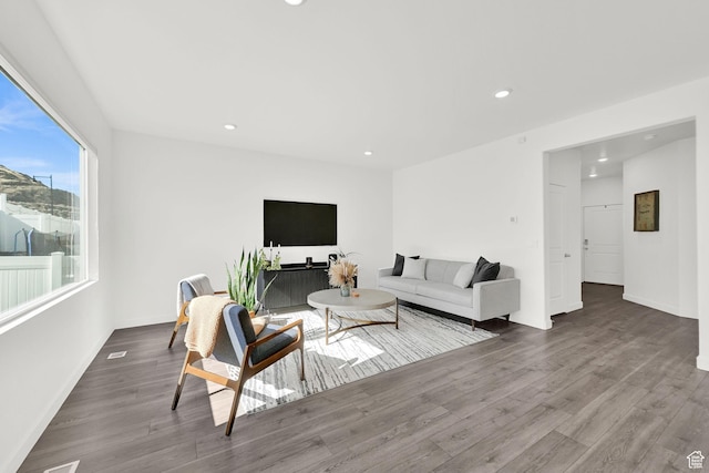 living room with baseboards, wood finished floors, and recessed lighting