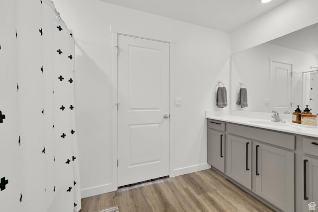 bathroom featuring vanity, baseboards, and wood finished floors