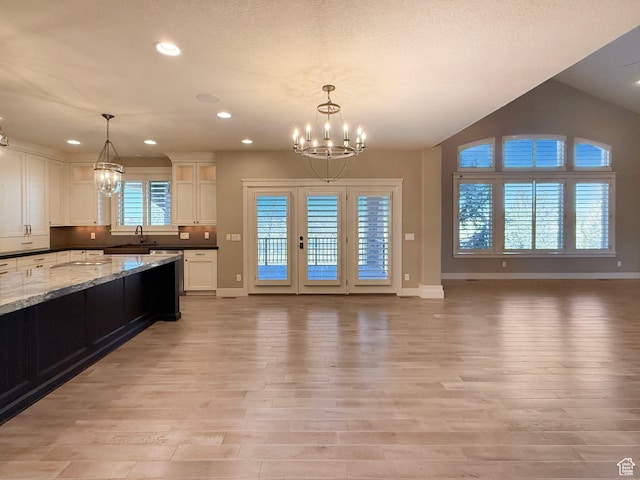 1663 N 3500 W, Plain City, UT 84404 - kitchen featuring an inviting chandelier, light wood-style flooring, white cabinetry, and open floor plan