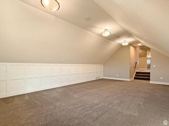 1663 N 3500 W, Plain City, UT 84404 - additional living space featuring lofted ceiling, visible vents, dark carpet, a textured ceiling, and baseboards
