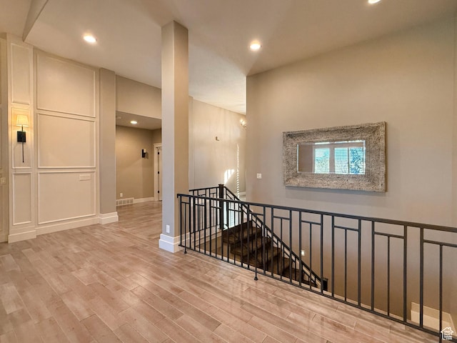 1663 N 3500 W, Plain City, UT 84404 - hallway featuring recessed lighting, visible vents, a decorative wall, an upstairs landing, and wood finished floors