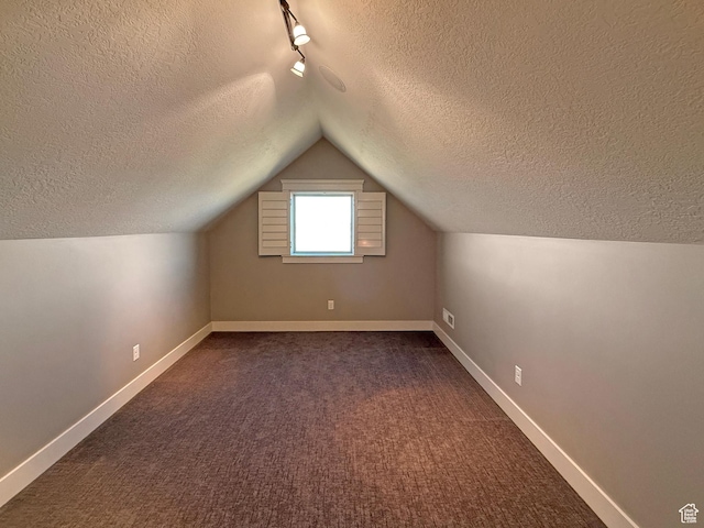 1663 N 3500 W, Plain City, UT 84404 - additional living space with vaulted ceiling, dark carpet, a textured ceiling, and baseboards